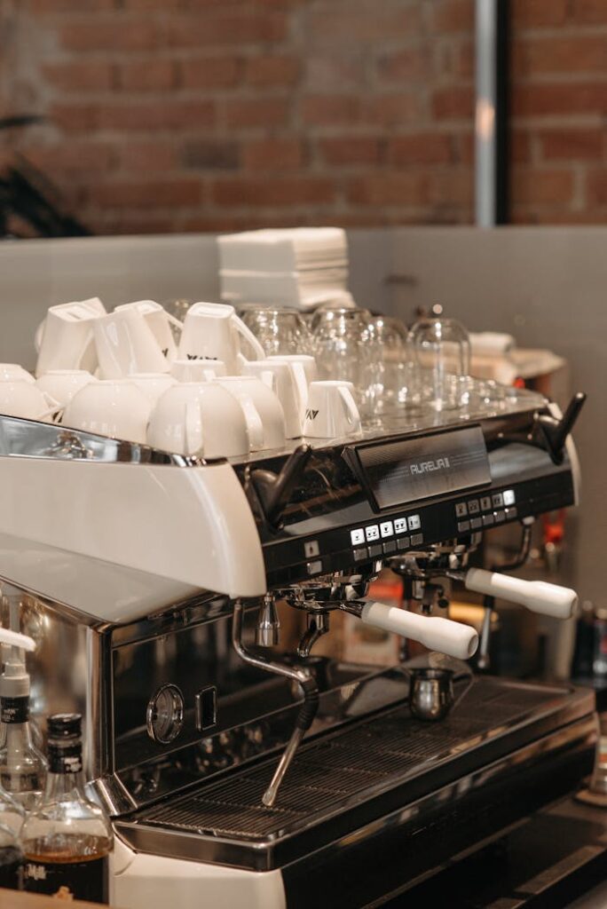 Close-up of a professional espresso machine with cups in a modern cafe setting.